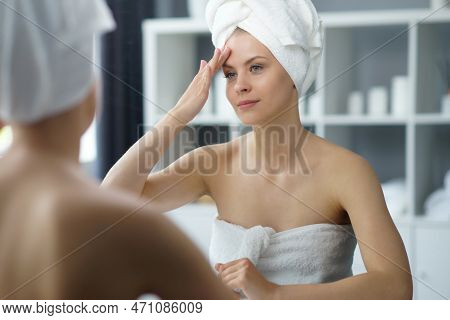 Young Woman Sits In The Bathroom In Front Of The Makeup Mirror And Does Cosmetic Procedures. Beautif
