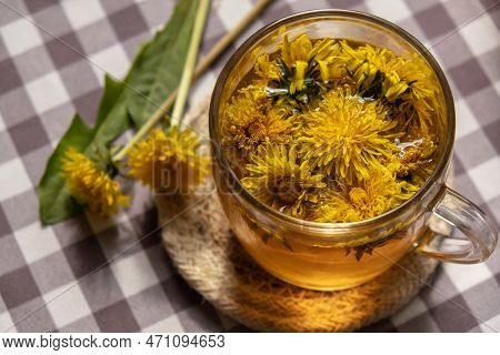 Dandelion Flower Healthy Tea In Glass Cup On Table. Herbal Medicine Delicious Tisane Tea From With F