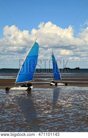 Arromanches, France - October 14 2012: Two People Having A Friendly Sand Yachting Race On Gold Beach