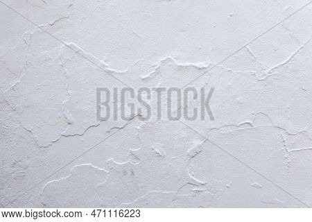 Empty White Grunge Wall Background. Old Decrepit White Plaster Wall With Rough Shabby Cracked Textur