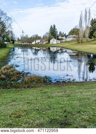 Home Are Refleced On A Pond In Seatac, Washington.