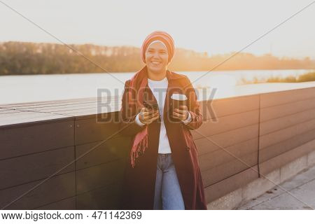Modern Arab Girl In Hijab Walking By Street And Drinking Coffee Take Away In Spring Time Morning, Co