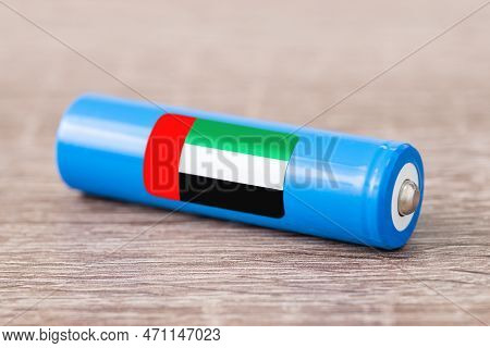 Close Up Shot Of Li-ion Battery On Wooden Table With Flag Of United Arab Emirates On Its Side. Conce