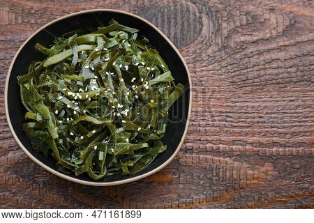 Fresh Laminaria (kelp) Seaweed In Bowl On Wooden Table. Space For Text