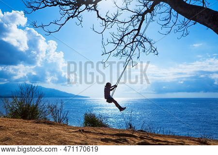 Happy Girl Have Fun Swinging High In Mid Air. Flying Up Upside Down On Rope Swing On Sea Beach. Trav