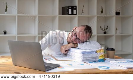 Stressed Business Man Sitting At Office Workplace. Tired And Overworked Business Man. Young Exhauste