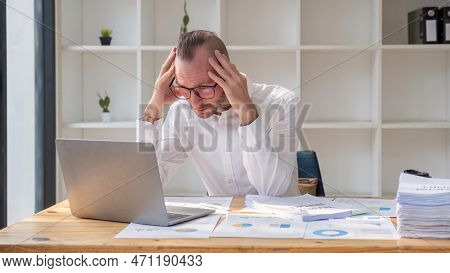 Stressed Business Man Sitting At Office Workplace. Tired And Overworked Business Man. Young Exhauste