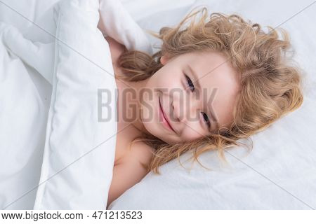 Good Morning. Child Wakes Up From Sleep In Bed. Kid Wakes Up In The Morning In The Bedroom.
