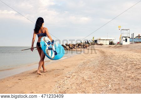 Woman Surfer With Surfboard Going To Surf At Seaside. Girl Holding Surfboard O And Goes To The Ocean