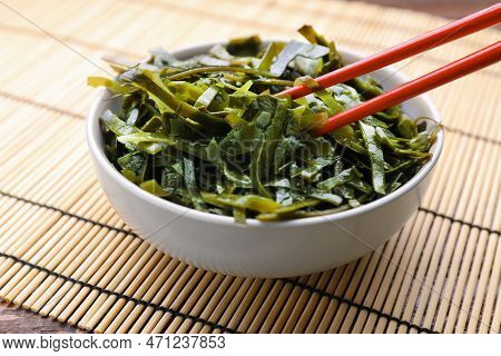 Fresh Laminaria (kelp) Seaweed In Bowl And Chopsticks On Table, Closeup
