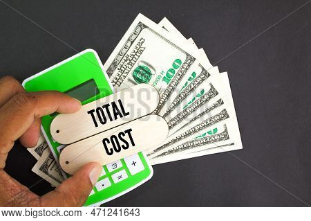 Calculator, Paper Money And Word Total Cost. The Concept Of Overall Cost Or Total Cost