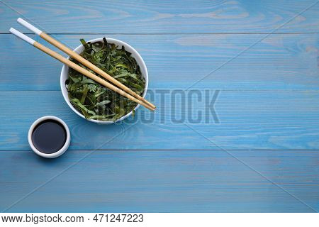 Fresh Laminaria (kelp) Seaweed Served On Light Blue Wooden Table, Flat Lay. Space For Text