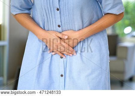 A Woman Holding Her Stomach With Her Hands, She Has Abdominal Pain And Abdominal Pain. From Stomach 