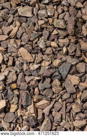 Closeup Image Of Background Made Of Pile Of Colorful Brown, Yellow And Red Crushed Stones. Vertical