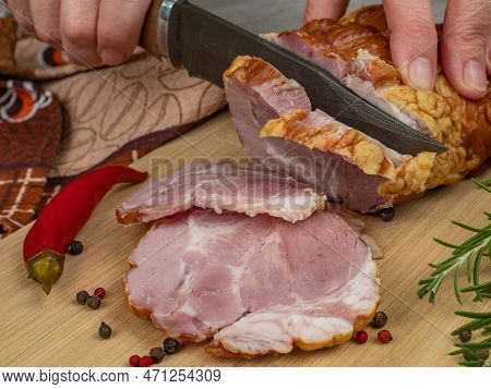 A Piece Of Juicy And Tasty Bacon Is Cut With A Kitchen Knife Into Appetizing Pieces. Close-up Of Fem