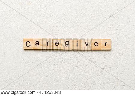 Caregiver Word Written On Wood Block. Caregiver Text On Table, Concept