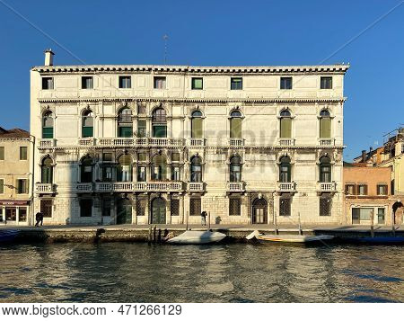 Venice, Italy - February 13, 2023: Facade Of Palace On Waterfront Of Canal Illuminated By Sunset Sun