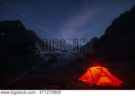 Awesome Mountain Landscape With Vivid Orange Tent Near Large Glacier Tongue Under Clouds In Night St