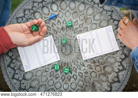 Two Friends, Men And Women Are Playing Yamb Game In Their Free Time In The  Spring Garden