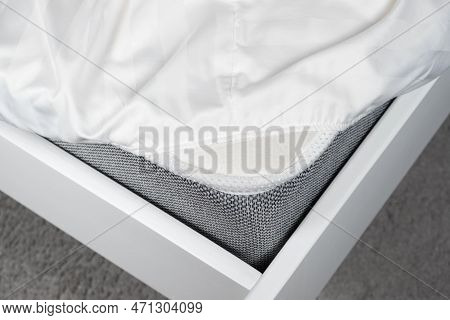 White Satin Sheet On An Elastic Band On The Mattress. Bed Linen On The Bed