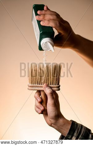 Male Hand Holds Talcum Brush And Accurate Pours Talcum Powder From A Bottle
