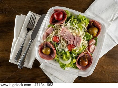 Flat Lay View Of Antipasta Salad With Ham, Salami Peppers And Lettuce In A Delivery Plastic Box And 