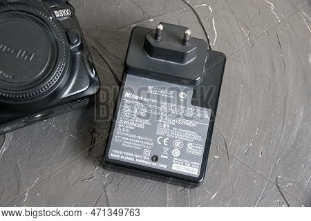 Ukraine, Chernihiv, February 21, 2023: Old Used Photo Equipment, Old Nikon Camera And Charger On A G