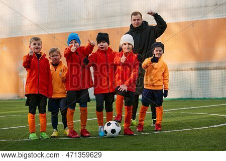Group Of Boys, Children, Football Players In Uniform Standing In A Line On Sports Field Grass Outdoo