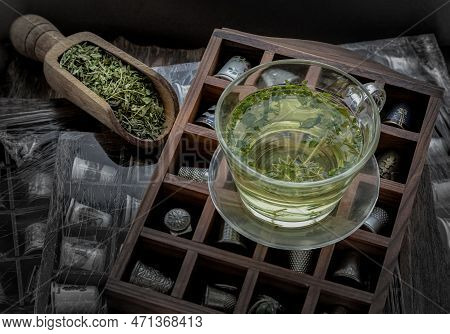 A Cup Of Hot Hemp Tea (cbd Herbal Tea) And Dried Organic Hemp Leaves Placed On Vintage Thimbles Coll