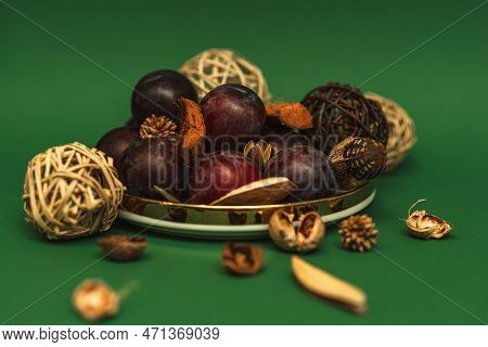 Uicy Plums On A Gold-rimmed Platter. On A Green Background.