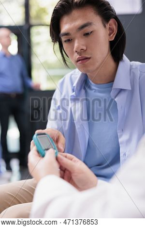 Elderly Physician Measuring Insulin And Glucose Level With Glucometer While Doing Health Examination