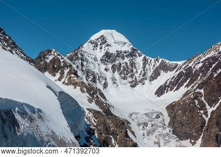 Scenic Alpine Landscape With Snow-covered Mountain Top And Steep Glacier Tongue With Icefall In Sunl