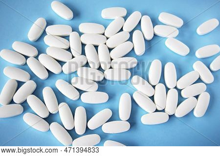 L Glutamine White Oval Tablets Scattered On A Blue Background, View From Above