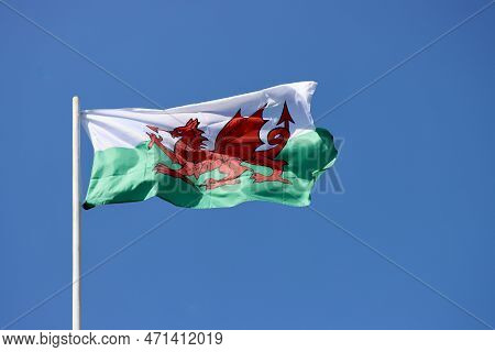 Wales Flag - Red Dragon Passant On White And Green - Bold And Proud Floating In The Wind Against Blu