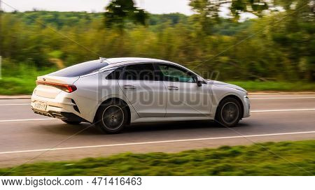Moving Kia K5 Sedan Car On A Rural Highway. Overspeed Out Of City Concept. Moscow, Russia - August 2