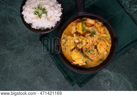 Fish Curry With Codfish, Pollack And Shrimps With Coconut Milk Served In Cast Iron Pan And Bowl Of R