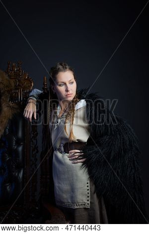 An Authoritative, Self-confident Woman In A Viking-style Fantasy Costume. Leaning On A High Chair. S