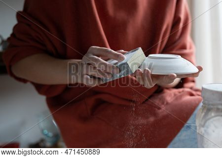 Woman Hand In Ceramics Polishing China Plate To Smoothen Or Remove Outdated Paint. Girl Restorer Cle