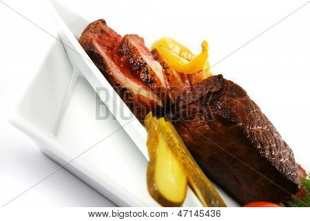 半生的牛肉肉与蔬菜在白板上