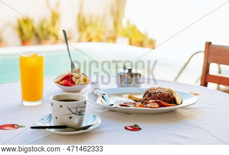 Close-up Of A Traditional Breakfast On A Table With A Swimming Pool In The Background. Morning Break
