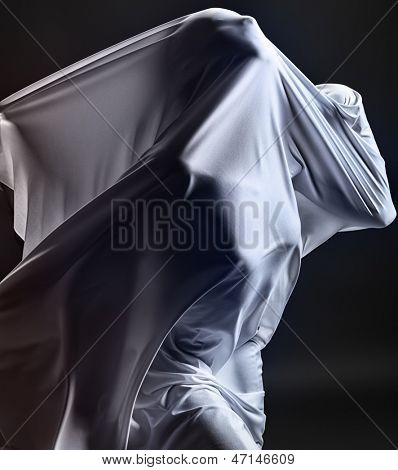 Art photo of a female silhouette breaking through the fabric. Struggle concept.
