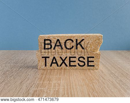 Back Taxes Symbol. Concept Words 'back Taxes' On Brick Blocks On A Wooden Table And Beautiful Blue B