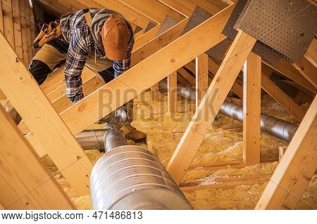 Professional Hvac Technician Installing Air Ducts In The Wooden Roof Section Of The Building. Ventil