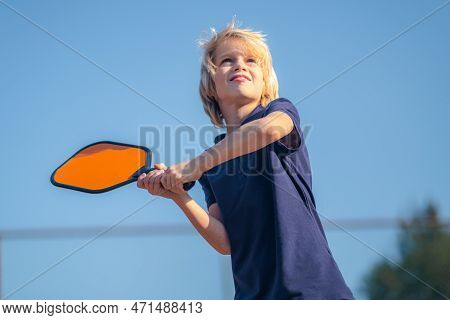 Happy Blonde Boy Playing Pickleball Game, Hitting Pickleball Yellow Ball With Paddle, Outdoor Sport 