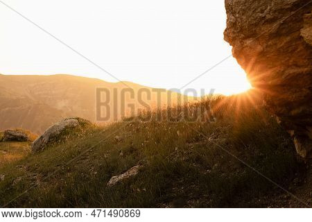 Idyllic Mountain Landscape - Big Boulder Closeup In Golden Sunset Sunlight With Sun And Sunbeams On 