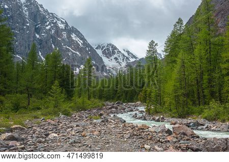 Dramatic Alpine Landscape With Turquoise Mountain River In Forest Valley In Sunlight With View To La