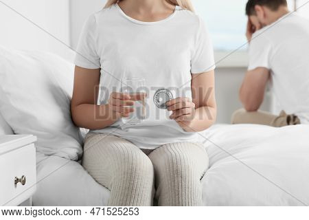 Couple In Bedroom. Woman Taking Emergency Contraception Pill, Closeup