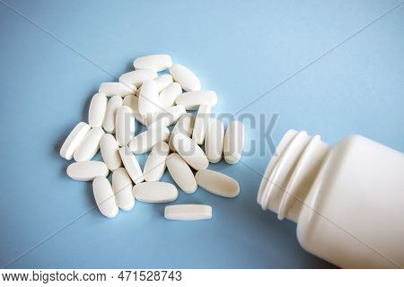 L Glutamine White Oval Tablets Lie On A Blue Background Next To The Jar.
