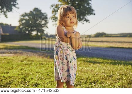Sad Child In A Sundress In Denmark At Sunset