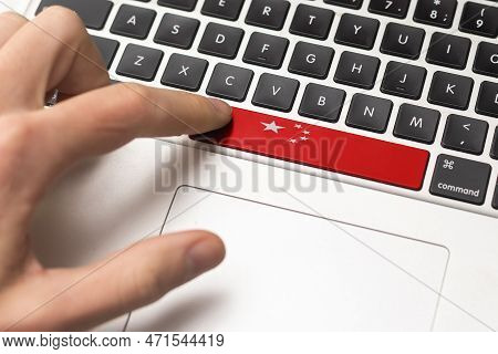 Online International Business Concept: Computer Key With The China Flag On It. Male Hand Pressing Co